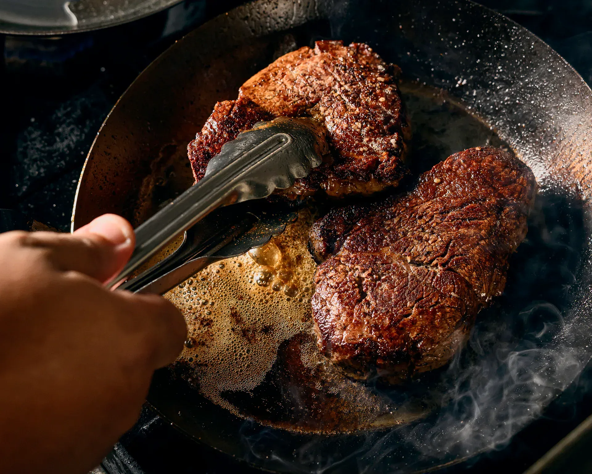 Steaks searing in a cast iron skillet at Petronita's, Jacksonville